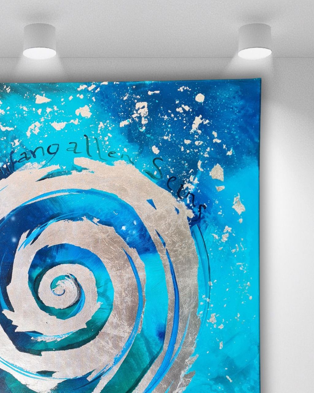 Abstrakte bläuliche Wandkunst mit silberner Spirale und schwarzer Schrift, beleuchtet von zwei Deckenlampen in einem weißen Raum.